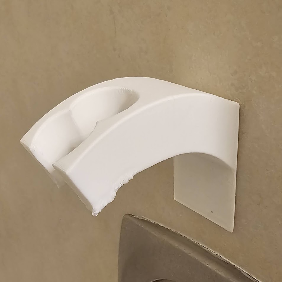 Shower head holder with adhesive backing
