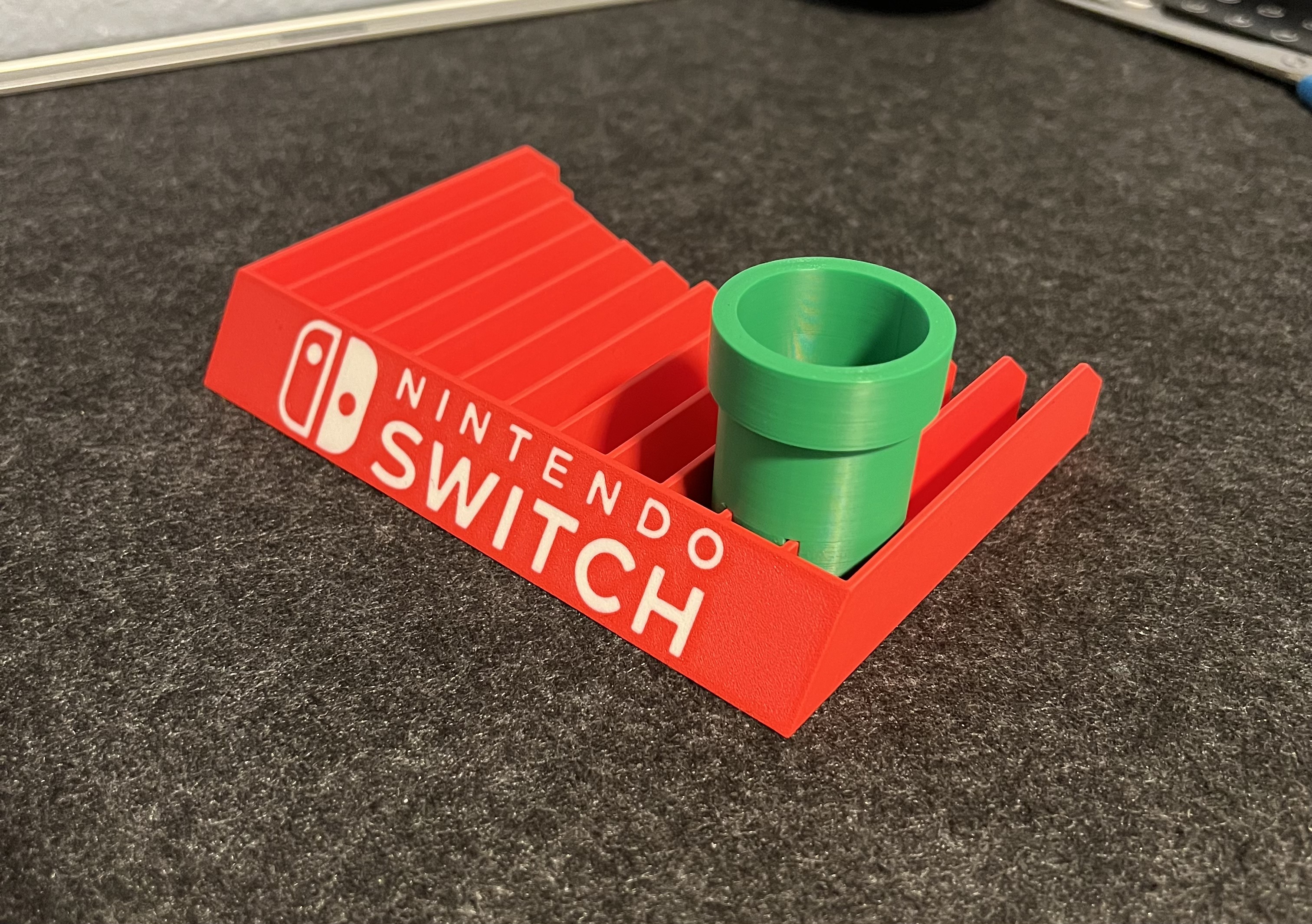 Nintendo Switch game holder with embedded logo and pipe by Sven