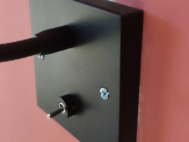 Mounting plate for wall mounted reading light