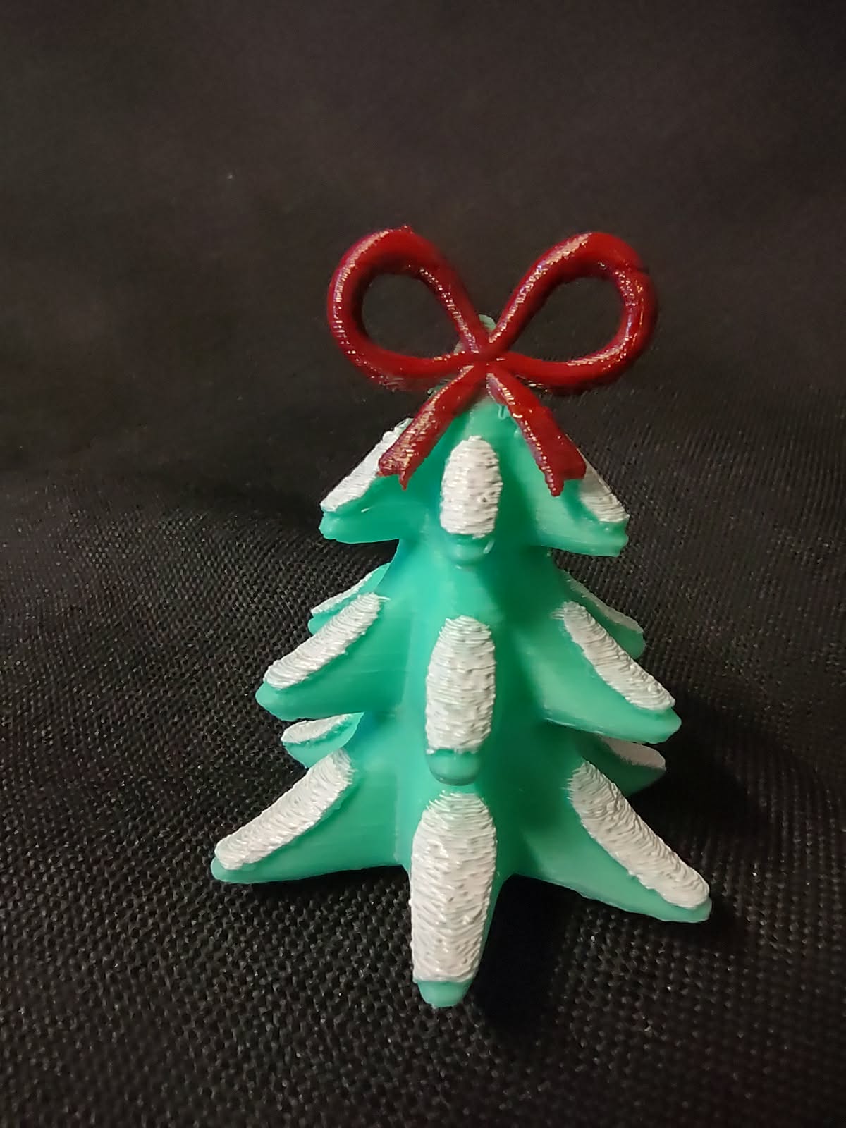 Snowy Christmas Tree topped with a Bow Figurine