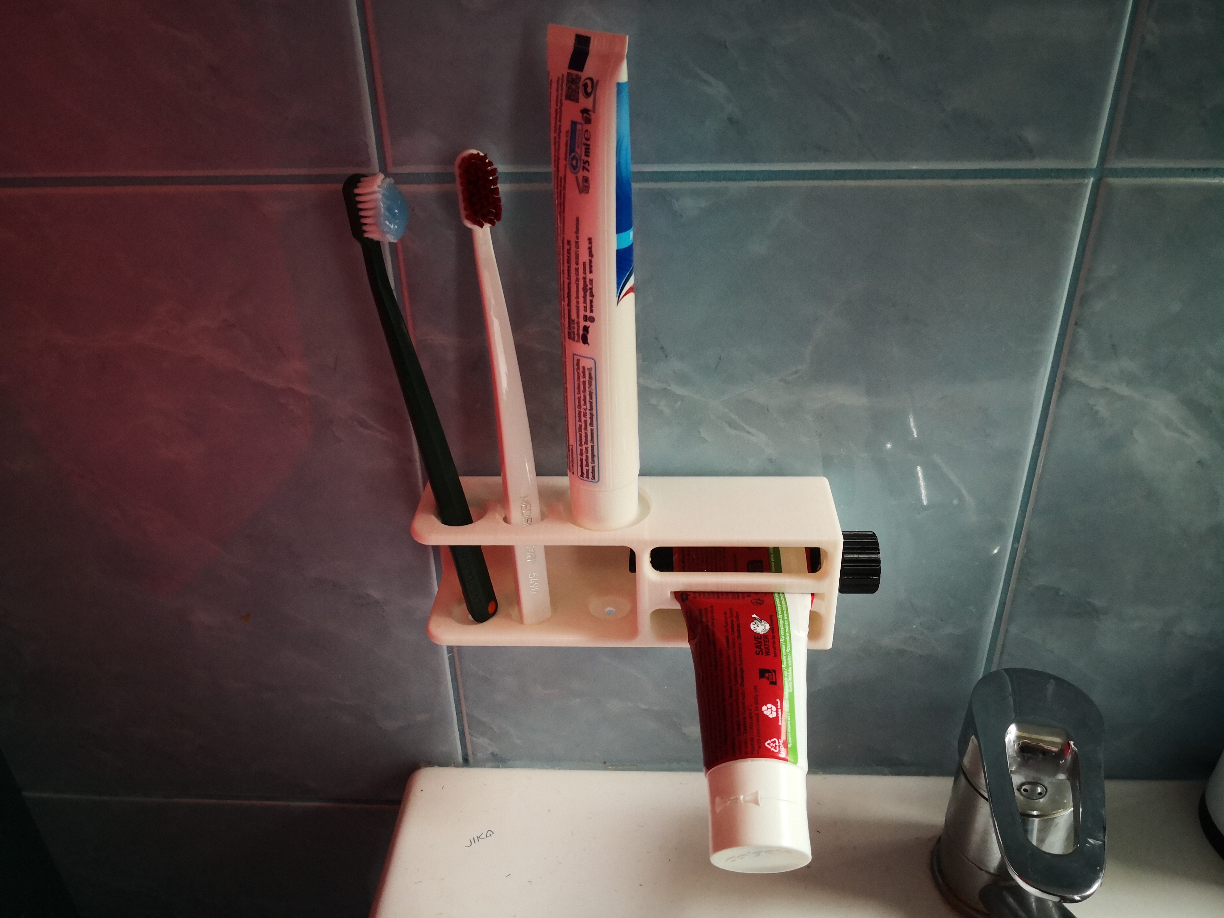 Toothbrush holder with integrated toothpaste squeezer