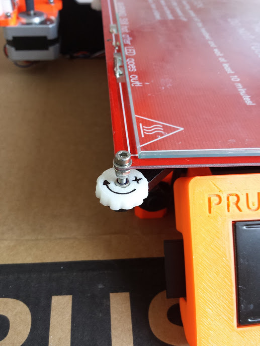 Prusa i3 bed adjuster with a direction arrow.
