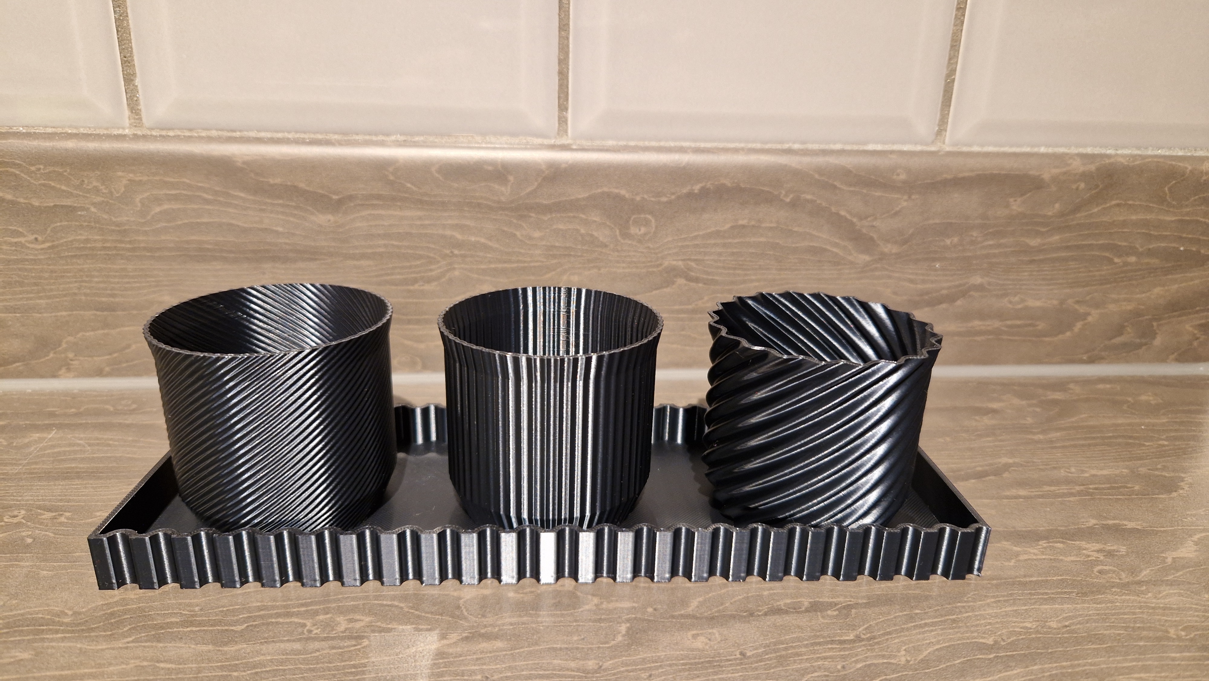 Trio of modern plant pots with drip trays