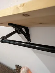 Shelf bracket for angled wall
