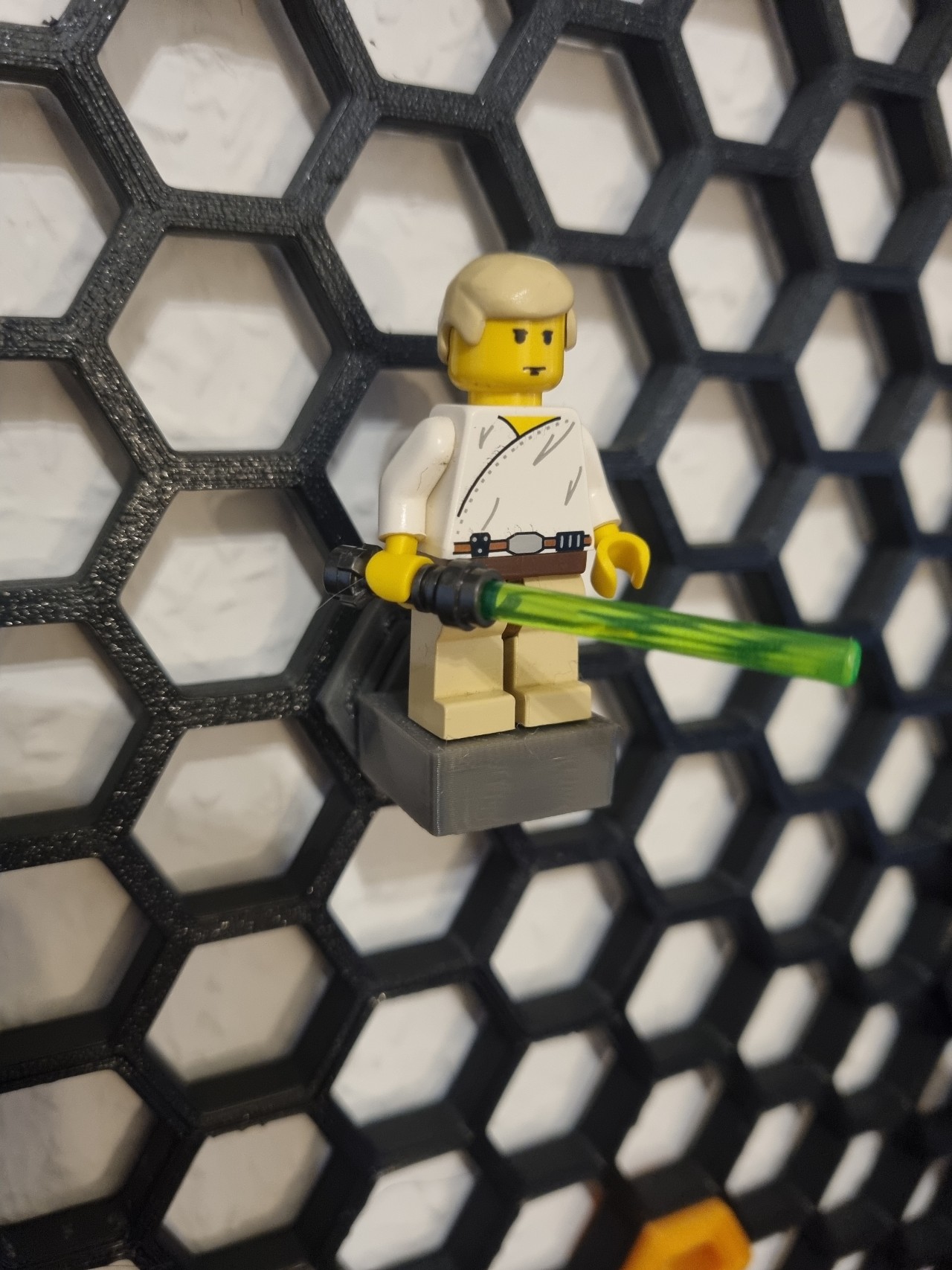 Lego minifigure holder for honeycomb wall