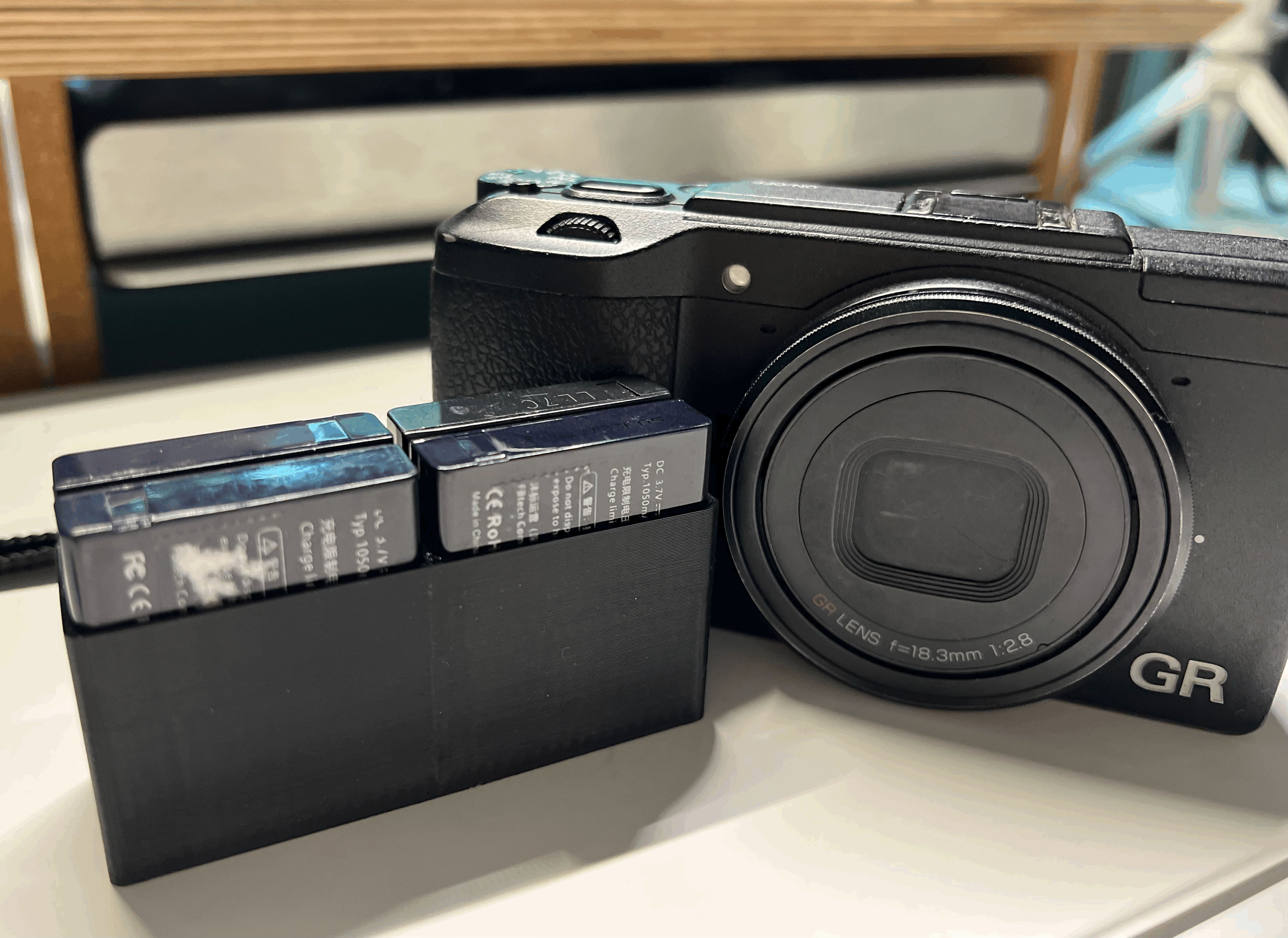 A compact case for Ricoh GR II securely holds 4 DB-65 batteries by