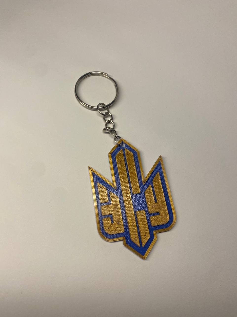 Брелок із тризубом та написом