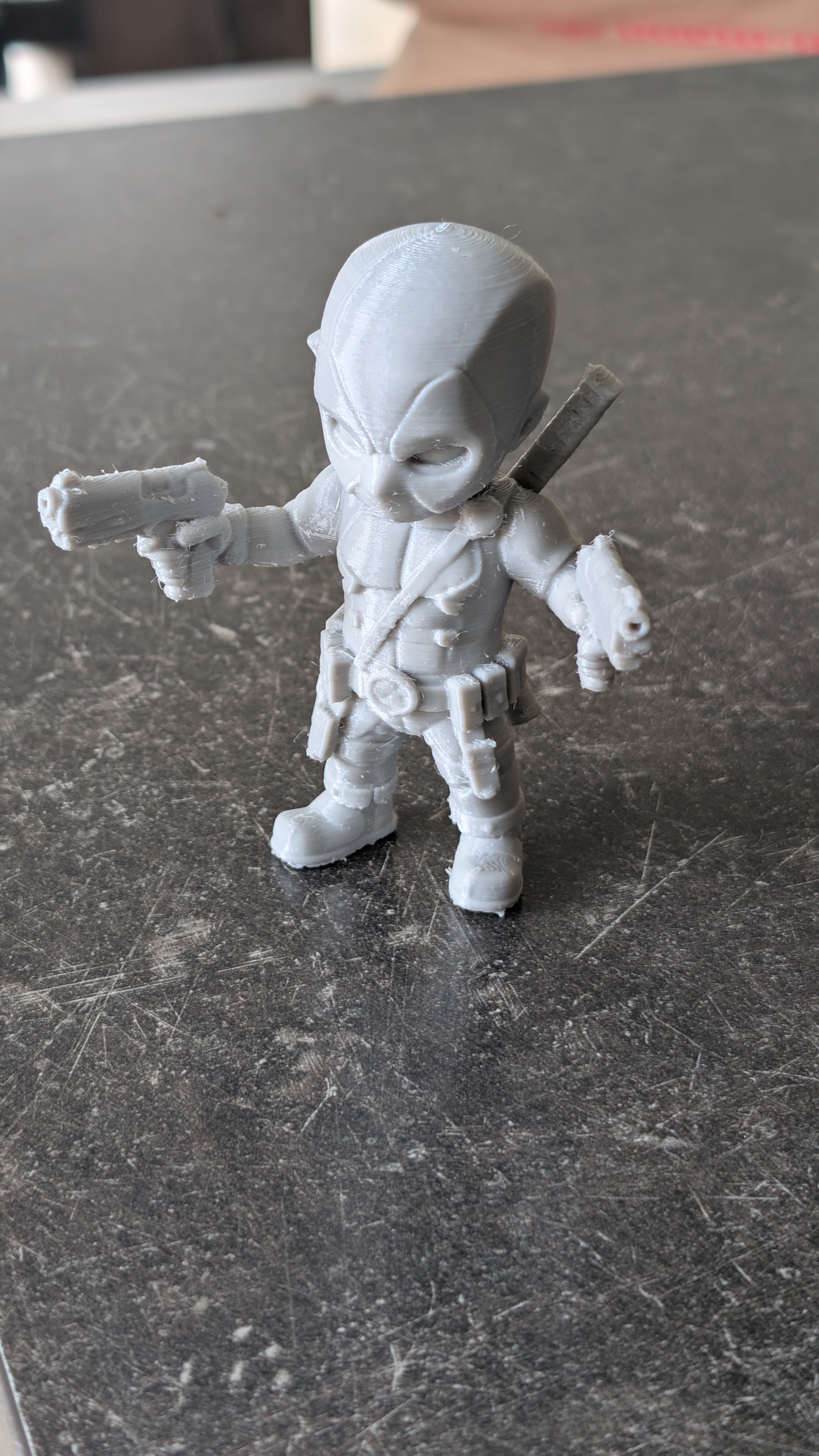 a baby Deadpool with two guns.