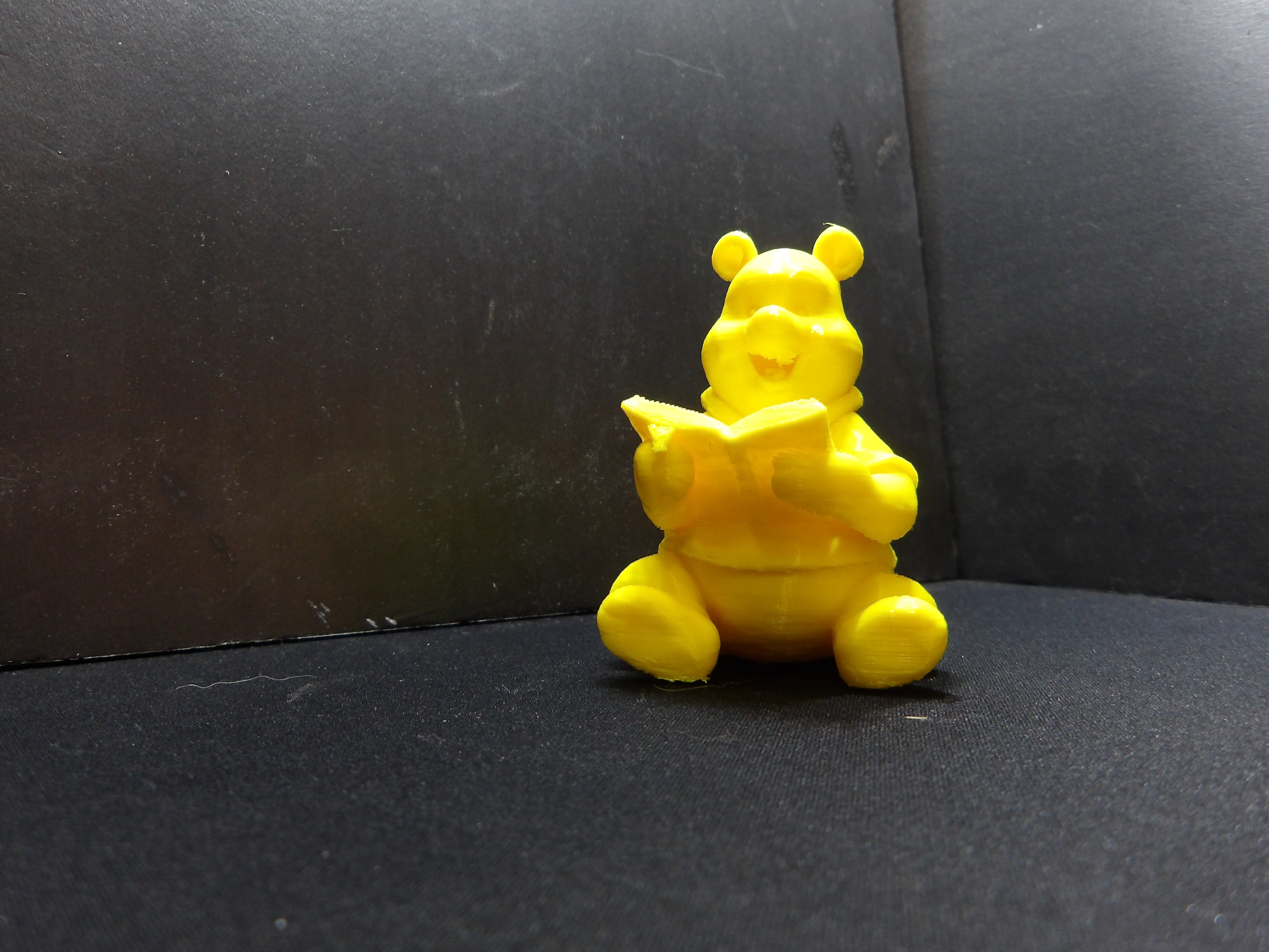 Winnie the pooh reading a book.
