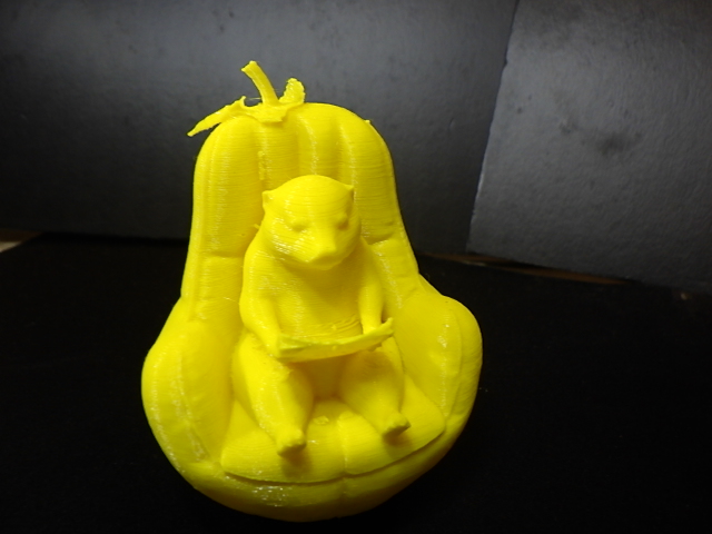 An Otter reading in a pear chair.