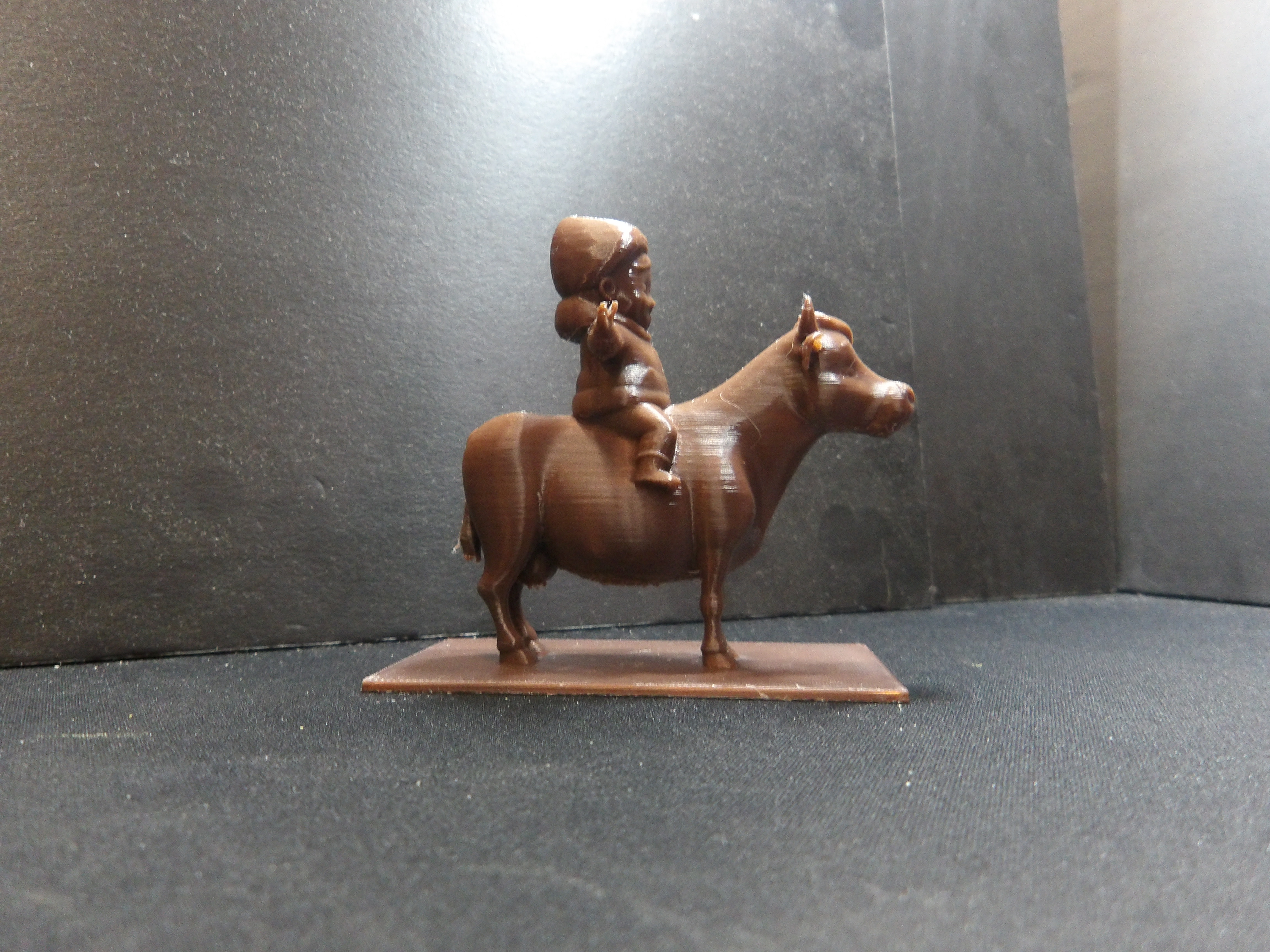 Young boy riding a cow.