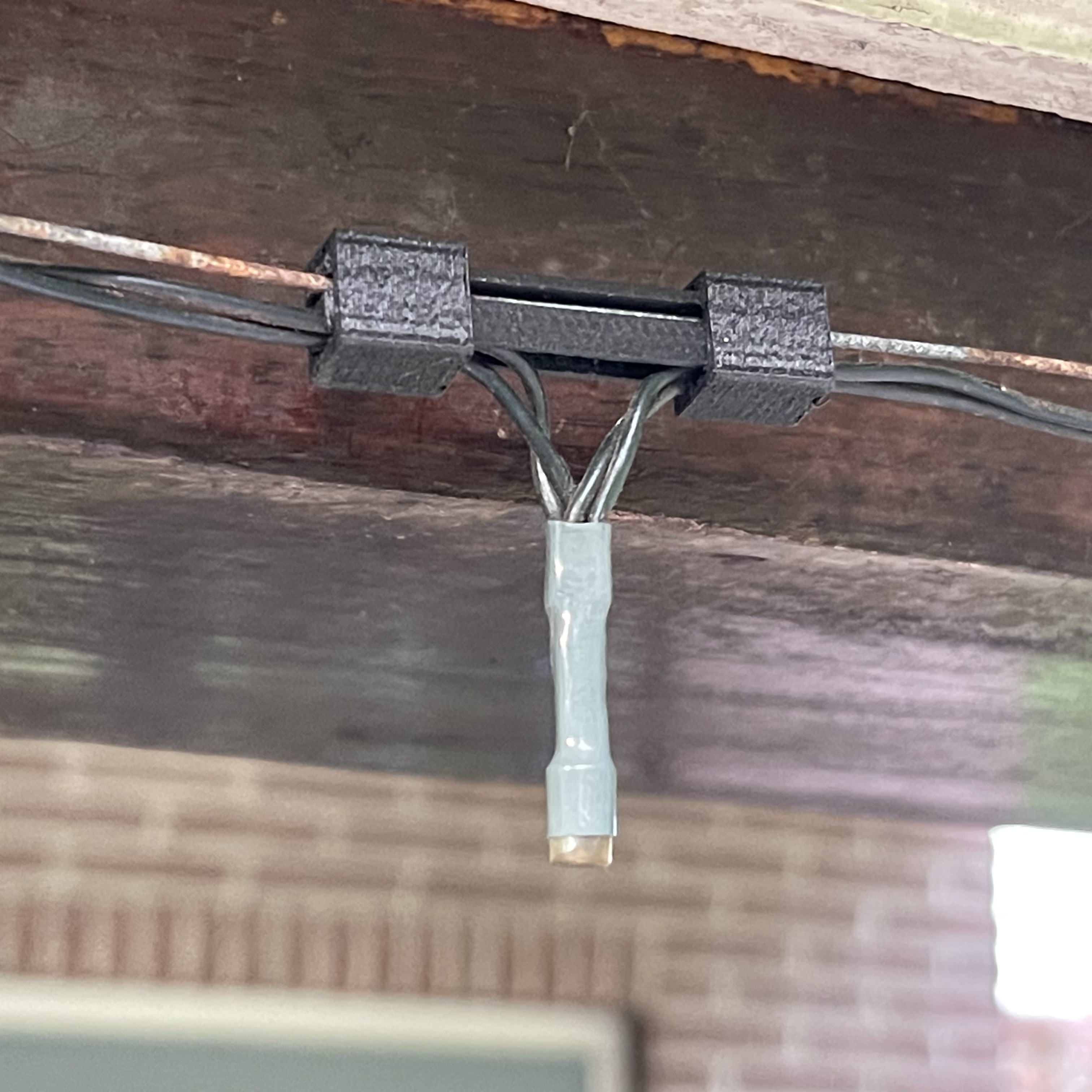 Sliding system for hanging outdoor lights from a metal wire