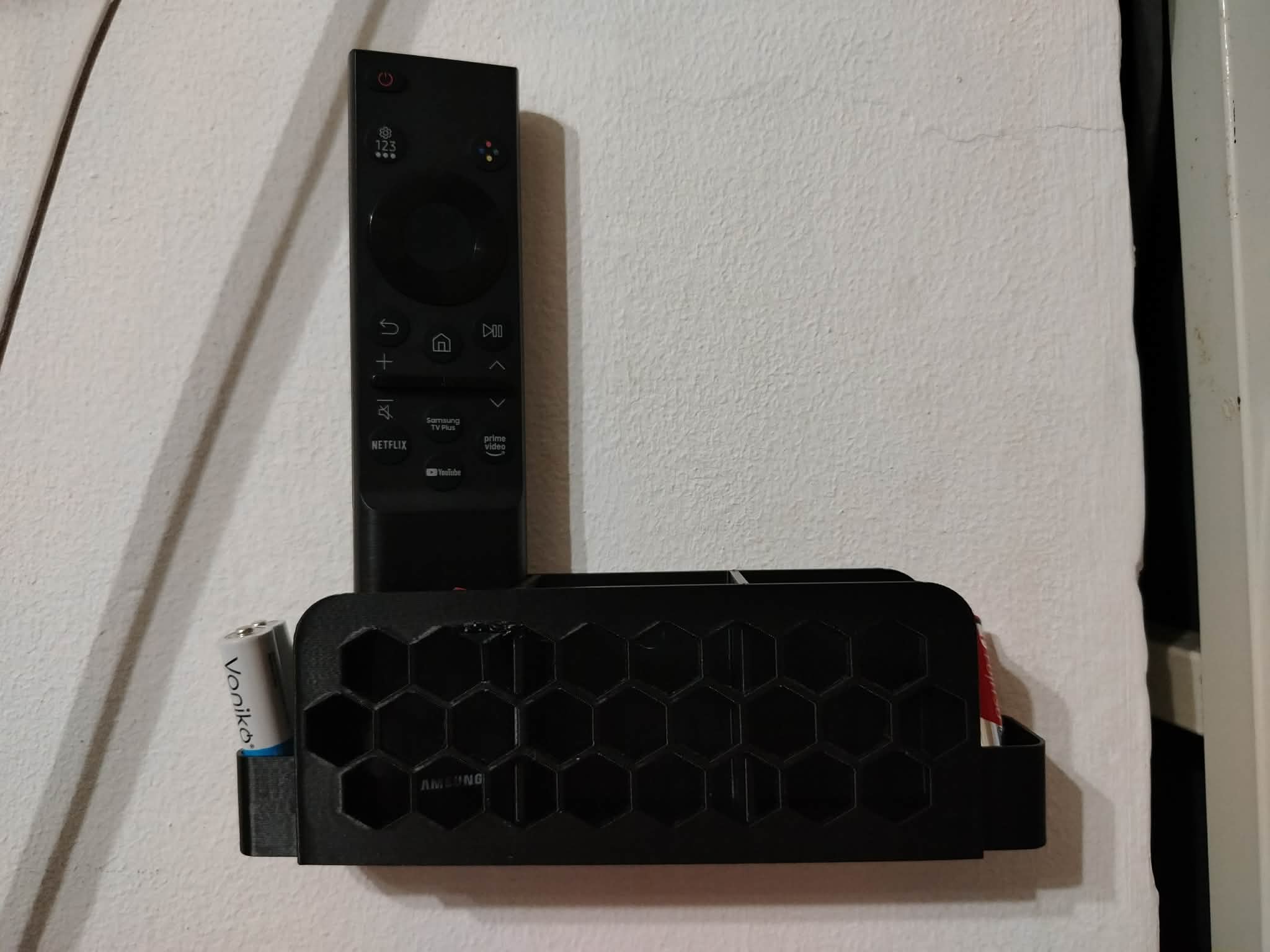 Wall Mounted Remote Holder With Honeycomb Pattern and AAA battery slots
