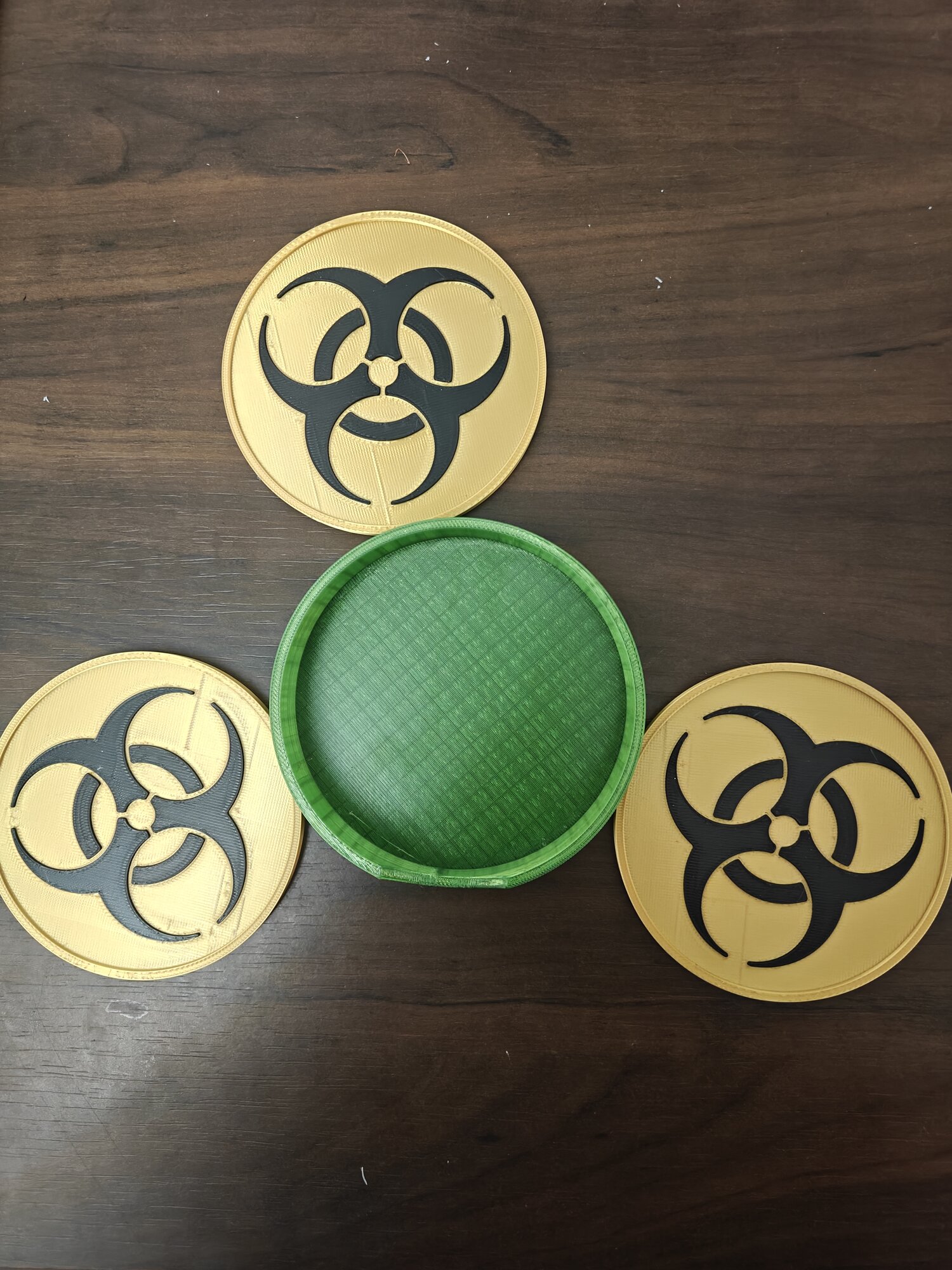 Biohazard Coasters — raised trefoil that lets go of a wet glass, plus caddy