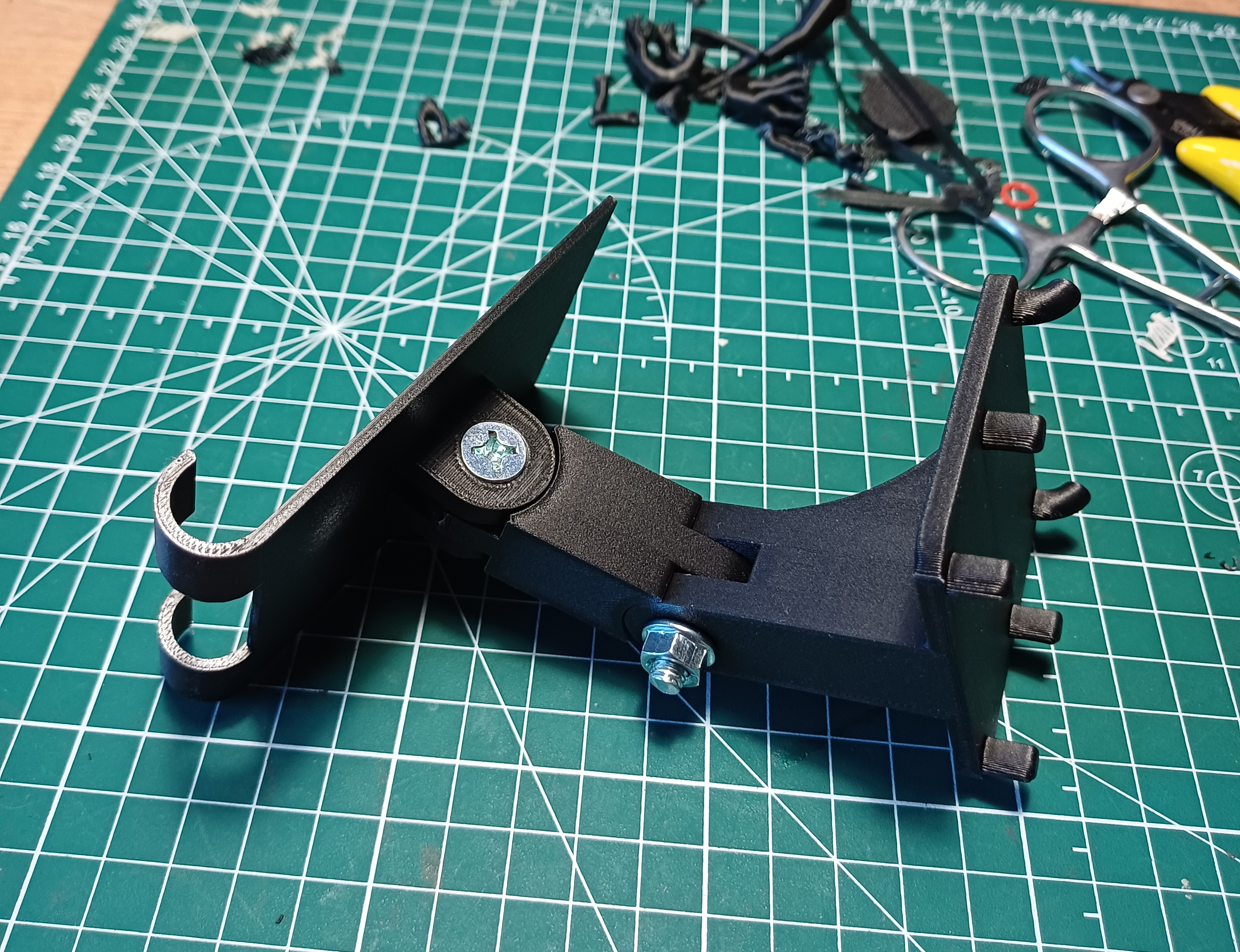 Adjustable phone holder for metal pegboard