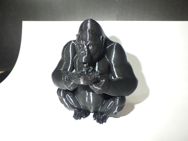 A Gorilla sitting eating pizza.