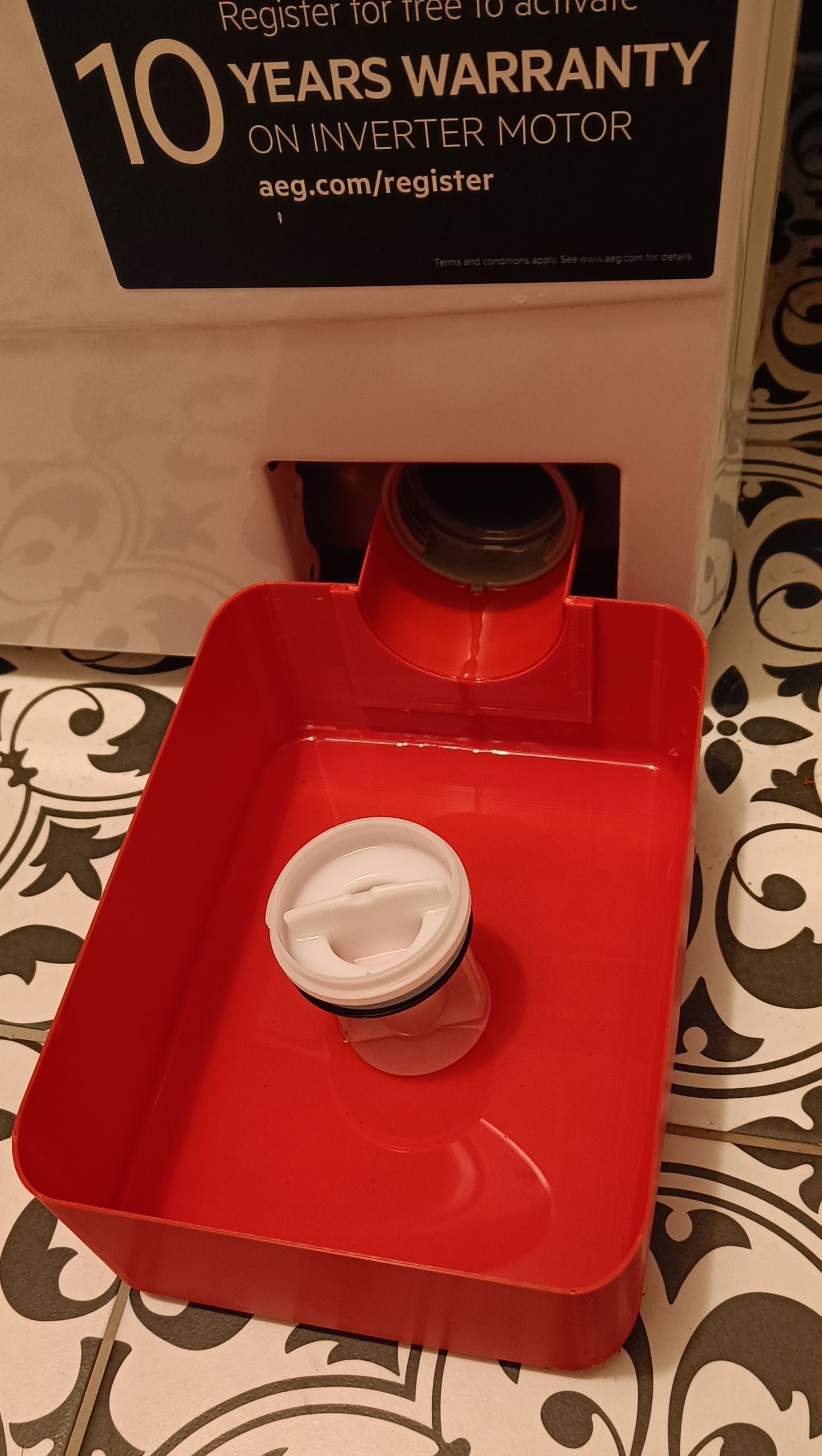 Vypouštěcí nádoba při čištění filtru pračky AEG ProSense L6SNE26SC / Drain container when cleaning the filter of an AEG ProSense L6SNE26SC washing machine